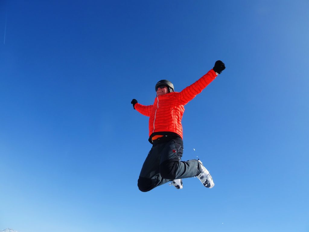 A man flying through the air while riding a snow board